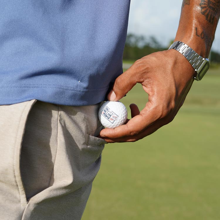 Golfer Taking Logo Ball Out of Pocket On the Golf Course